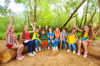 children raising their hands while sitting